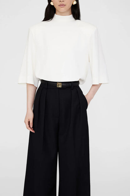 monogram belt in black by anine bing on model with white tee